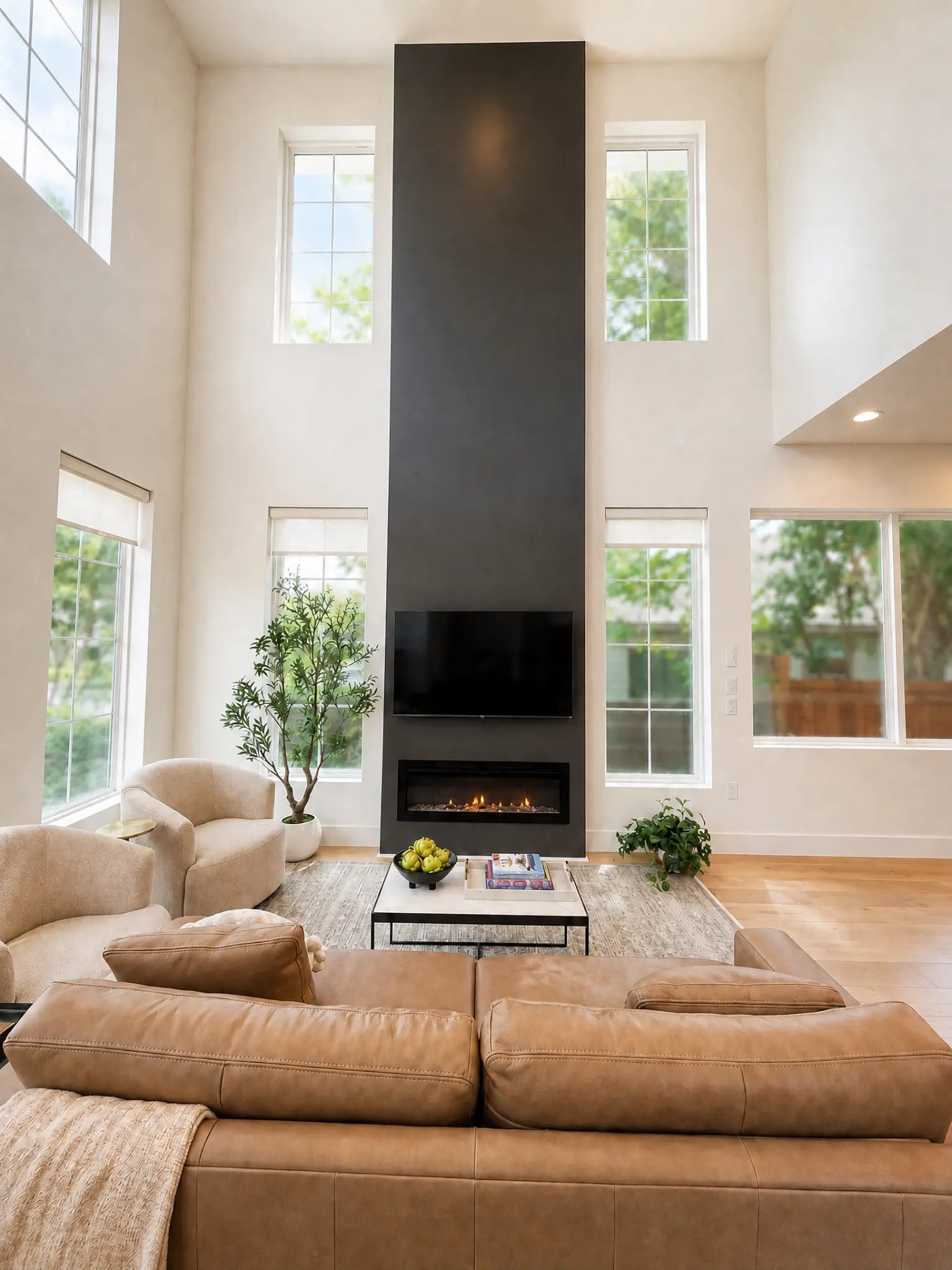 Living room at The Urban Casa with a fireplace, tall windows, and afternoon light