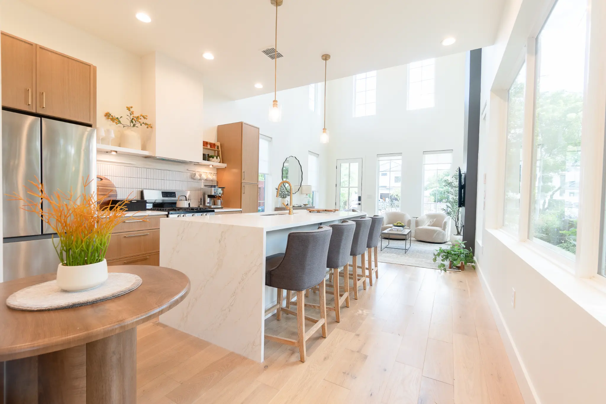 Sunlit kitchen and island at The Urban Casa, with a dining table set with yellow flowers